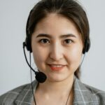 Smiling female call center agent wearing a headset, providing customer support.